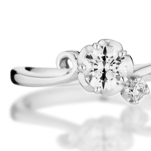 婚約指輪:中石のダイヤを花びらで包み込みこんだ印象的なS字アームのリング