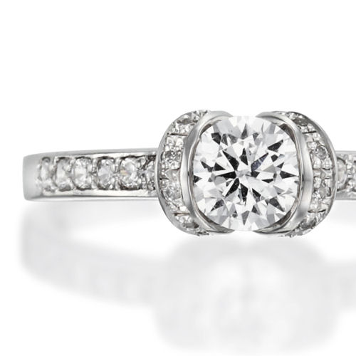 婚約指輪:中石を両脇から支えるセッティングはその存在感を強調し美しい輝きを放つリング