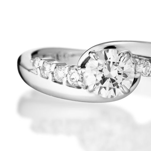 婚約指輪:重厚感のあるプラチナとメレダイヤで中石を包み込むS字ラインのデザイン